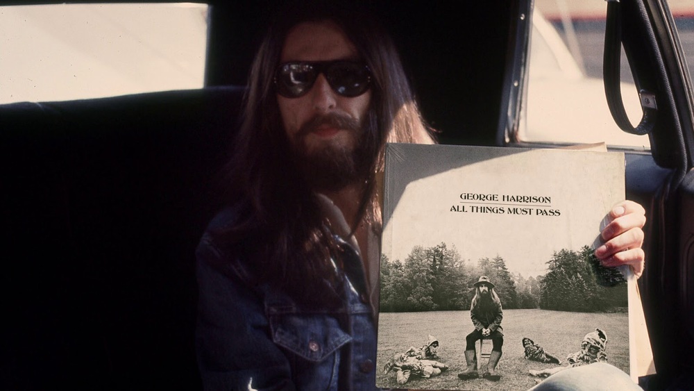 George Harrison holding his album