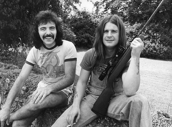 Tony Iommi and ozzy handling a gun